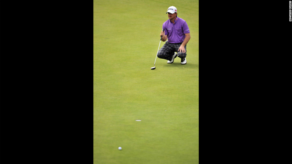 McDowell squats to line up a putt on the second green.