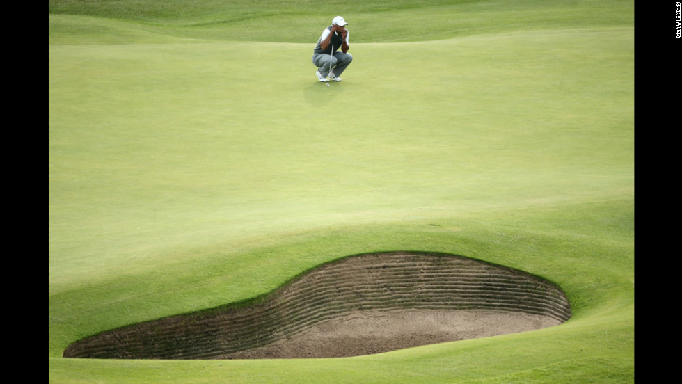 Woods waits to play on the 18th green.