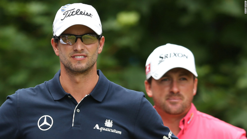 Overall leader Scott, left, waits with McDowell on the first tee during the final round of play.