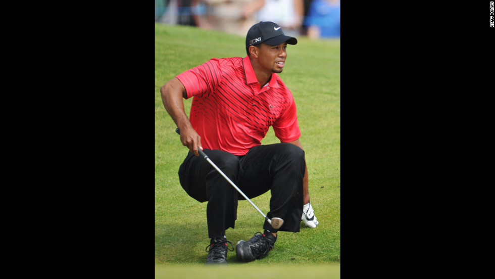 Tiger Woods stumbles and watches the path of his bunker shot on the sixth hole Sunday.