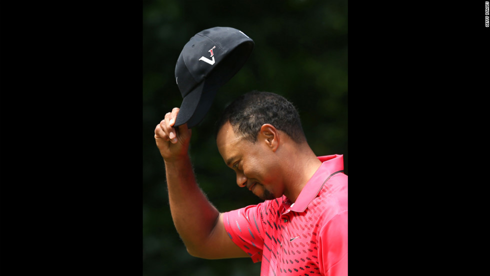 Woods tips his cap to the crowd on Sunday.