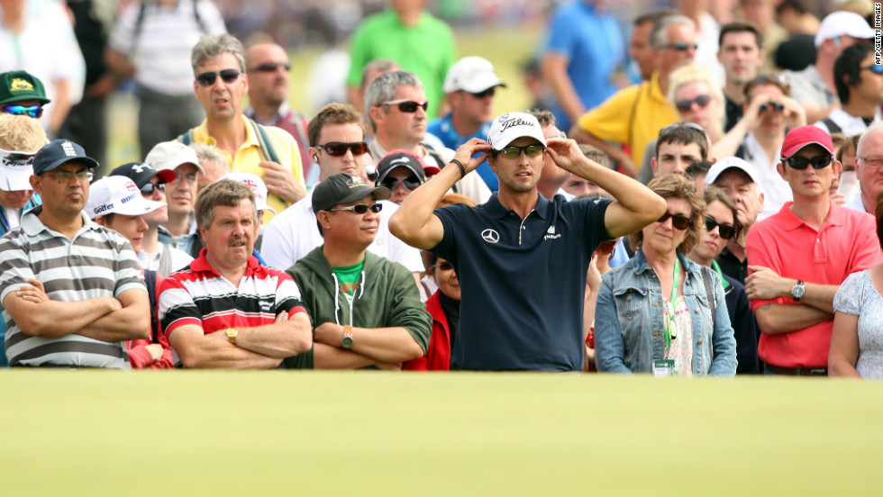 Adam Scott looks at his putting line on a green Sunday.