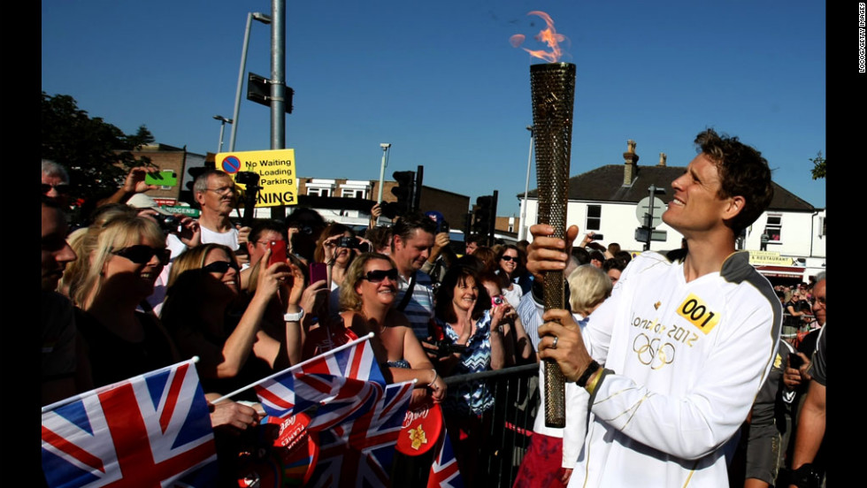 James Cracknell carries the Olympic flame on the torch relay leg through Kingston Upon Thames on Tuesday, July 24. The flame is traveling 2,875 kilometers (1,786 miles) through the United Kingdom over 70 days. Its journey ends Friday at the opening ceremony of the London 2012 Olympic Games.