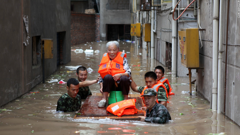 Rescuers evacuate an elderly woman from her flooded home in Chongqing, southwest China, July 23, 2012.