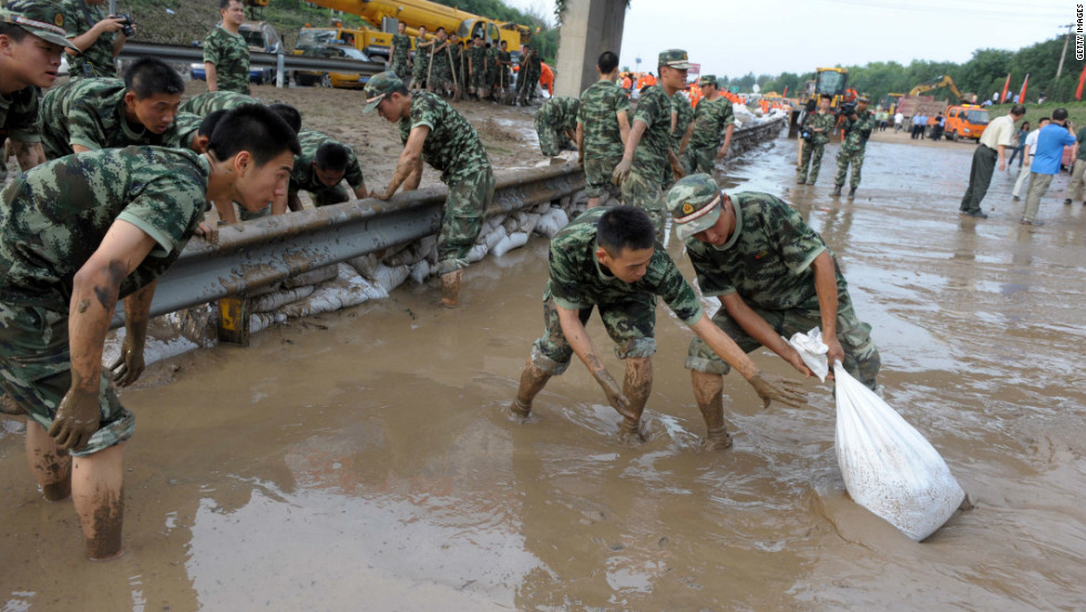 Soldiers try to clear water on a section of the Beijing-Hong Kong-Macao expressway on July 23, 2012 in Beijing, China. 