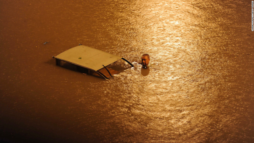 The downpour causes chaos on a flooded Beijing street on Saturday, July 21. About 6.7 inches of rain fell in some parts of the Chinese capital and as much as 18 inches in the suburban Fangshan district. 