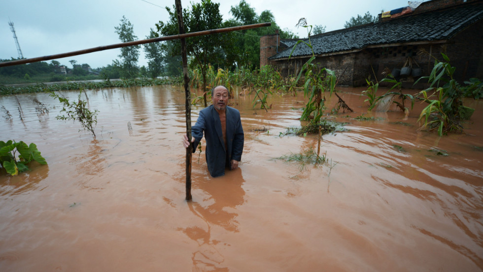 A farmer stands in his flooded field on the outskirts of Chongqing in southwest China on Sunday, July 22.