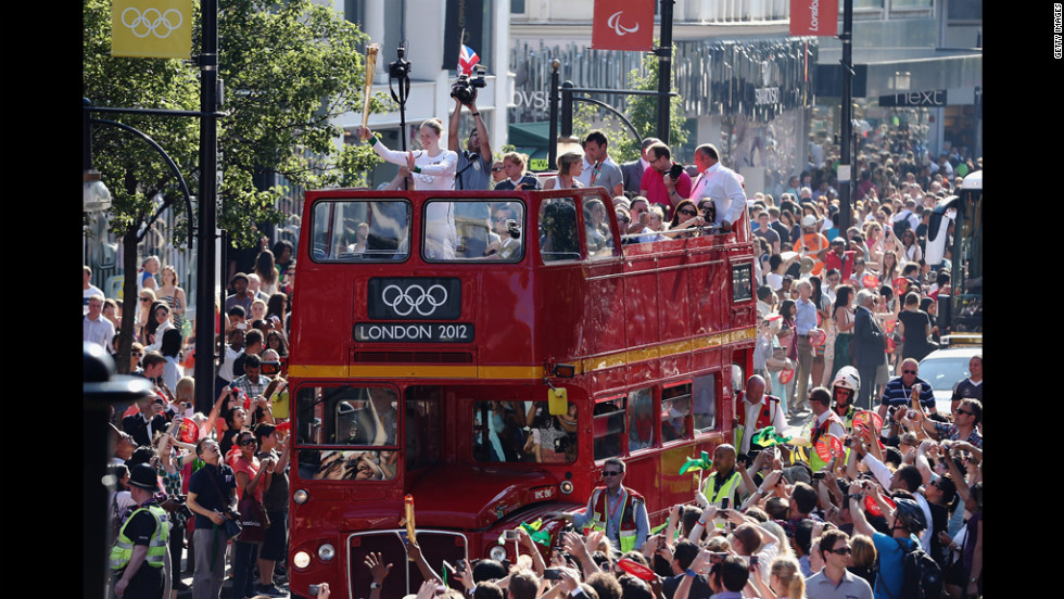 The Olympic torch is carried Thursday on top of an open top bus down Oxford Street in London.