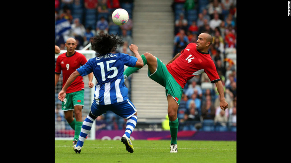 Morocco&#39;s Houssine Kharja, right, controls the ball against Honduras&#39; Roger Espinoza during a first-round Group D match Thursday in Glasgow, Scotland.