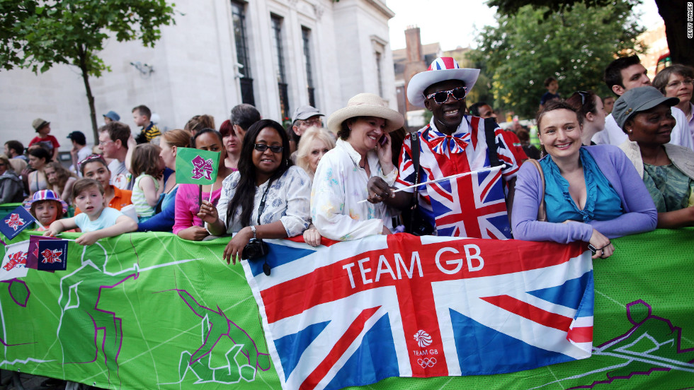 Spectators gather as the Olympic torch is carried from Islington Town Hall on Thursday. London cheered on the torch as it made its way past the city&#39;s historic landmarks.