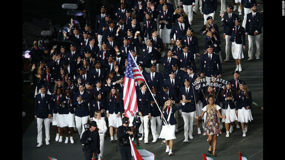 Mariel Zagunis of the United States Olympic fencing team carries her country&#39;s flag.