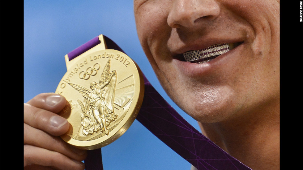 Lochte poses with medal on Saturday. His dental braces bear the U.S. flag.