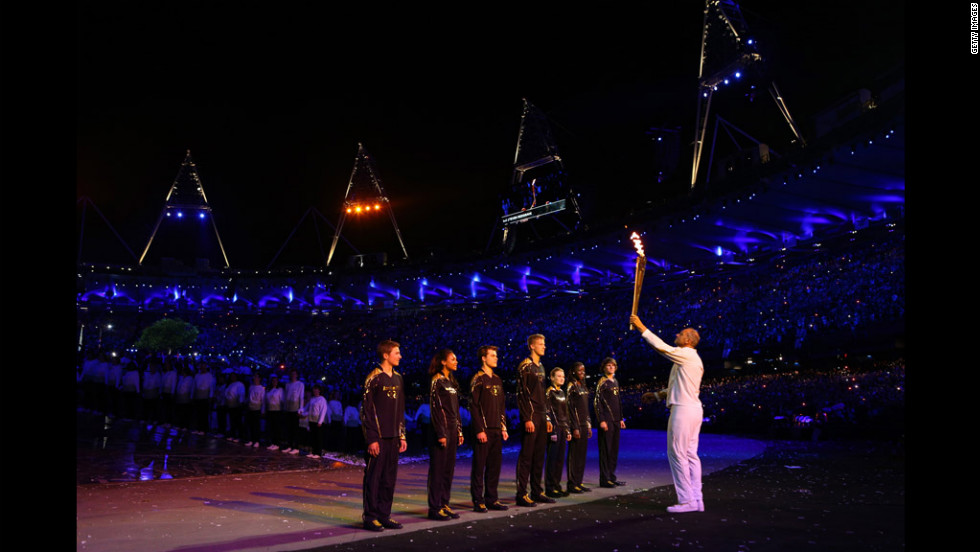 Torchbearer Sir Steve Redgrave hands the Olympic flame over to the seven young athletes who represent Britain&#39;s hopes for the next Olympics.
