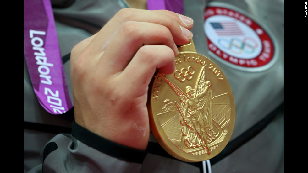 The gold medal hangs from the Olympian&#39;s neck.