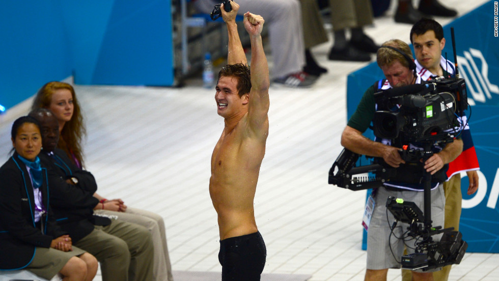 American swimmer Nathan Adrian raises his hands in triumph. 