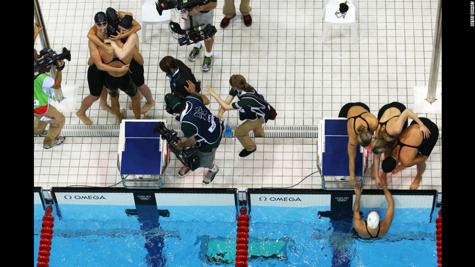 At left, Shannon Vreeland, Missy Franklin, Allison Schmitt and Dana Vollmer of the United States celebrate next to the Australian team.