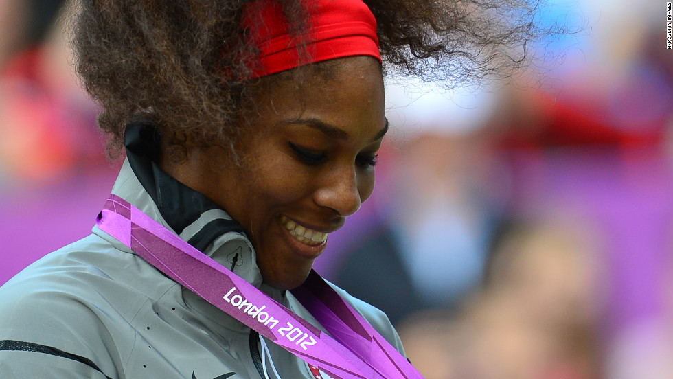 Williams admires her gold medal during the medal ceremony after defeating Sharapova in the women&#39;s singles match.