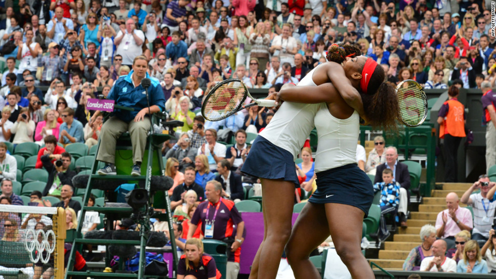 Venus Williams, left, and Serena Williams embrace after winning the women&#39;s doubles gold medal match on Sunday.