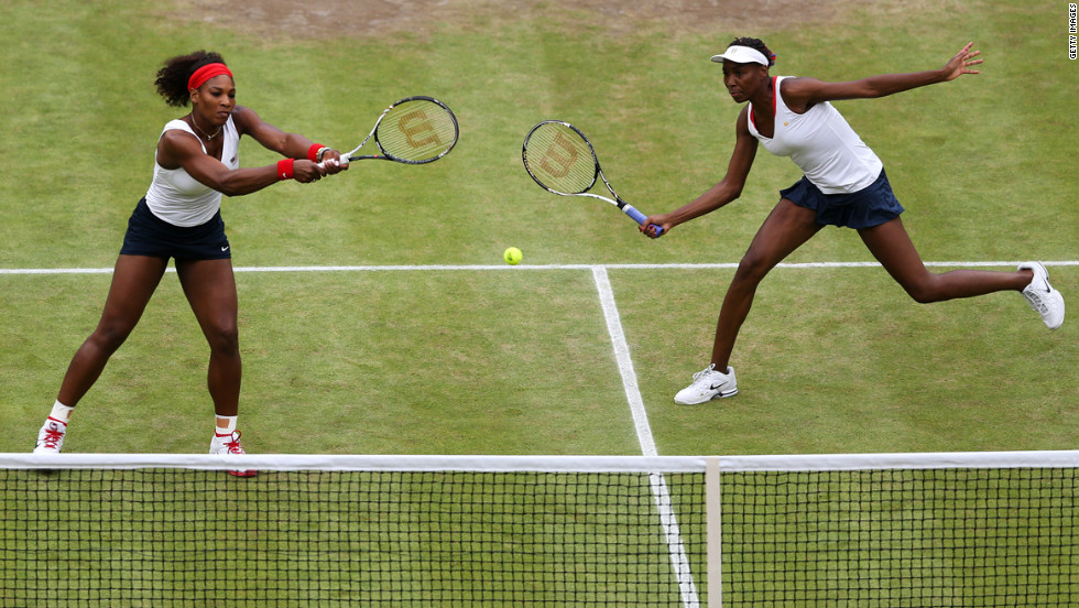 Serena Williams, left, and Venus Williams, right, return a shot during the women&#39;s doubles final.