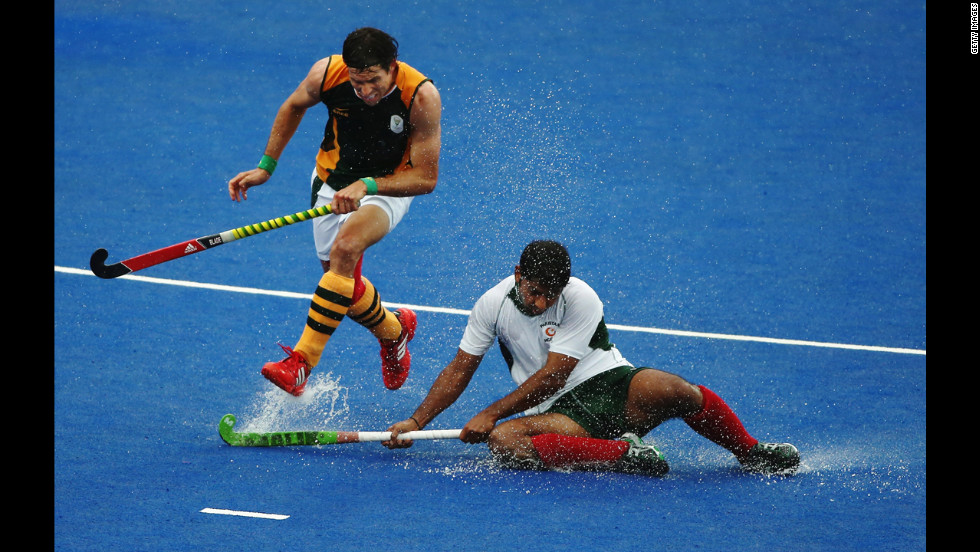 Thornton McDade of South Africa and Muhammad Imran of Pakistan challenge for the ball during a men&#39;s field hockey match.