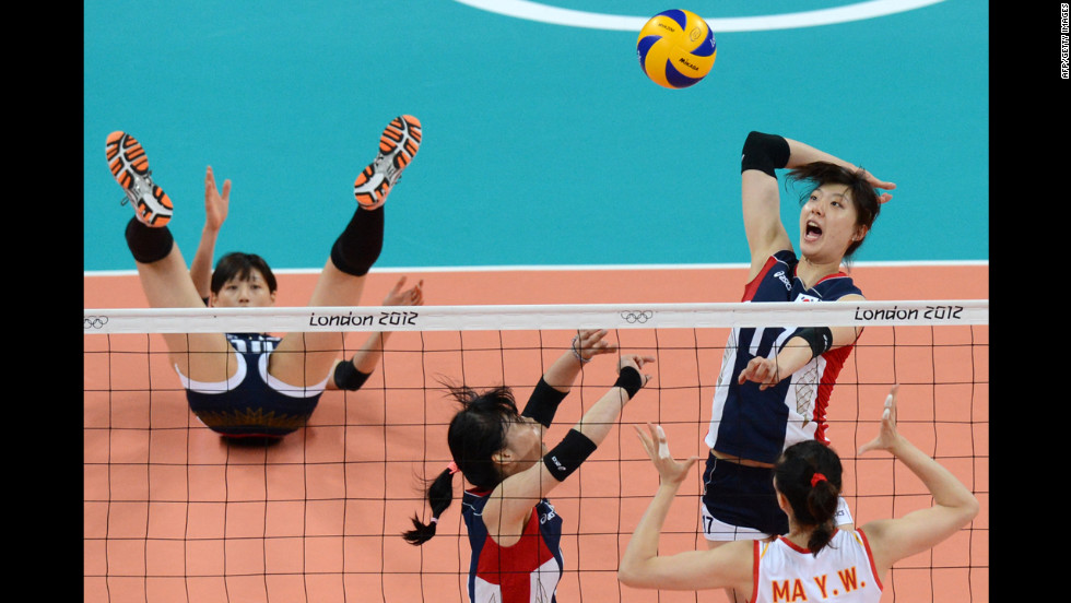 South Korea&#39;s Yang Hyo-Jin, top right, spikes as China&#39;s Ma Yunwen, bottom right, attempts to block during the women&#39;s preliminary pool B volleyball match.