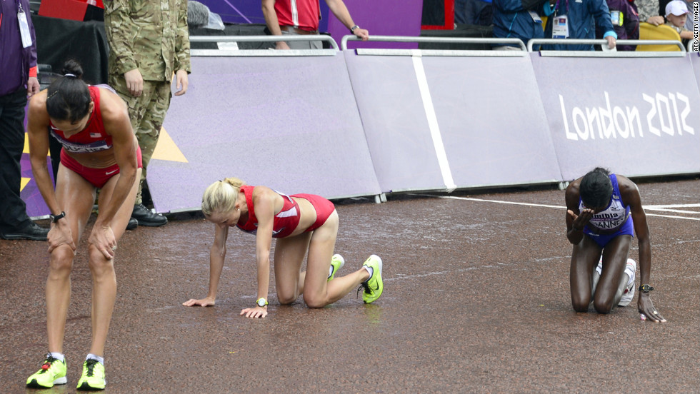 Namibia&#39;s Helalia Johannes, right, and other competitors begin to recover after finishing the women&#39;s marathon.