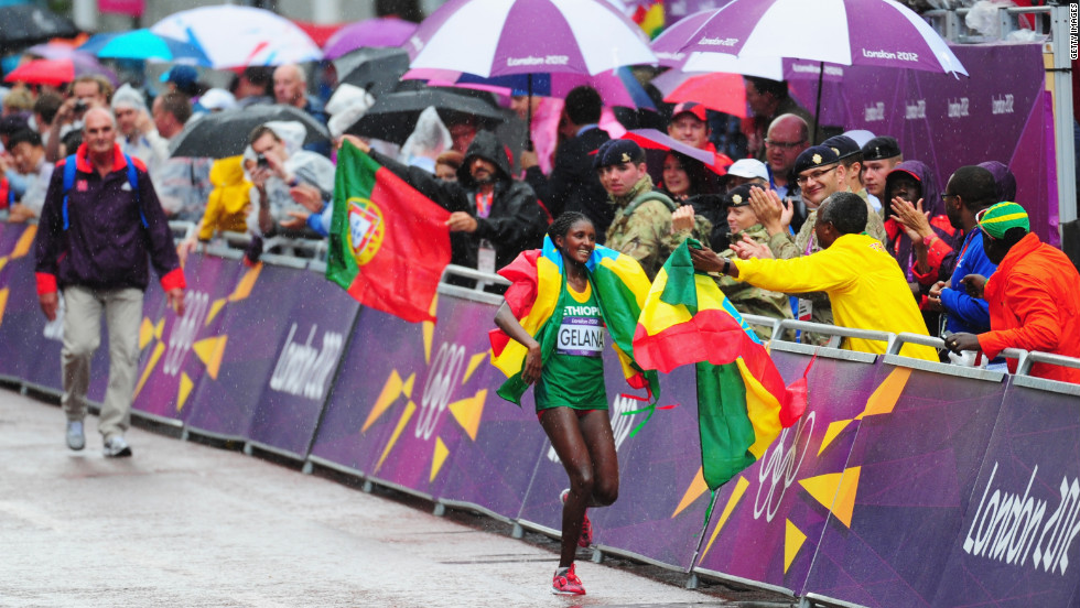 Wrapped in her nation&#39;s flag, Tiki Gelana of Ethiopia celebrates winning the women&#39;s marathon.