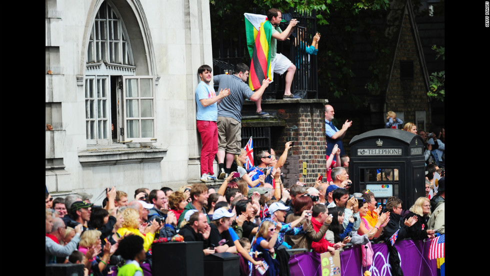 Spectators take photographs and shout encouragement to the runners in the women&#39;s marathon.