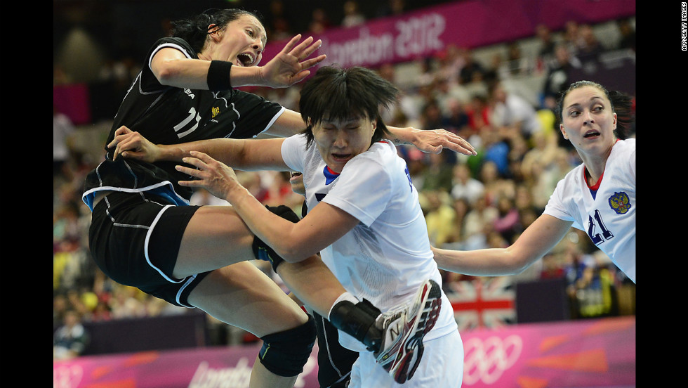 Montenegro&#39;s Bojana Popovic, left, vies with Russia&#39;s Liudmila Bodnieva, center, during a women&#39;s preliminary handball match.