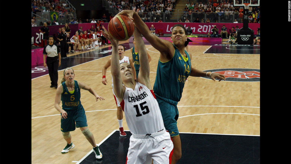 Canadian forward Michelle Plouffe, center, struggles with Australian center Elizabeth Cambage for control of the ball during the women&#39;s preliminary round group B basketball match.