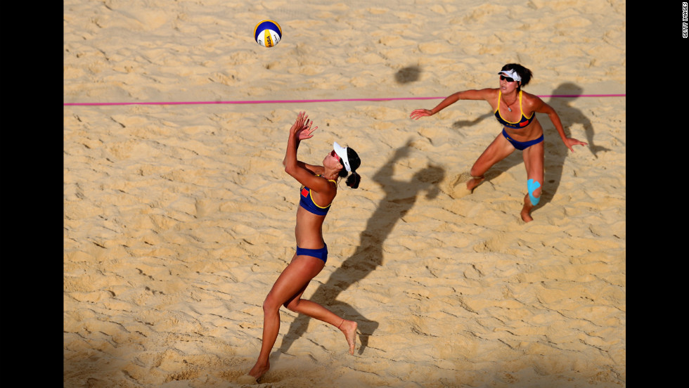 Xi Zhang of China, left, sets the ball for teammate Chen Xue during the women&#39;s beach volleyball quarterfinal match against Austria.