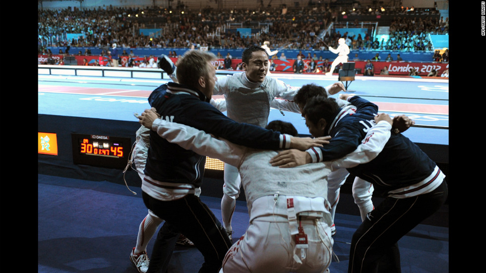 Team Japan celebrates defeating China during the men&#39;s foil team quarterfinals fencing event at the ExCeL center Sunday.