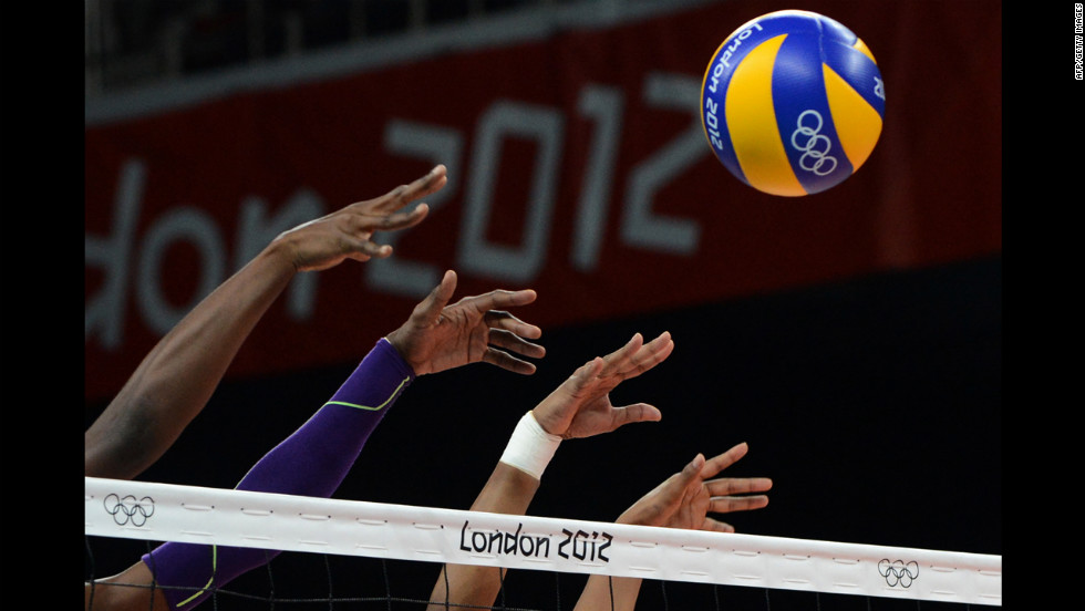 Members of the Dominican Republic women&#39;s volleyball team attempt to block a shot during a preliminary match against Algeria.