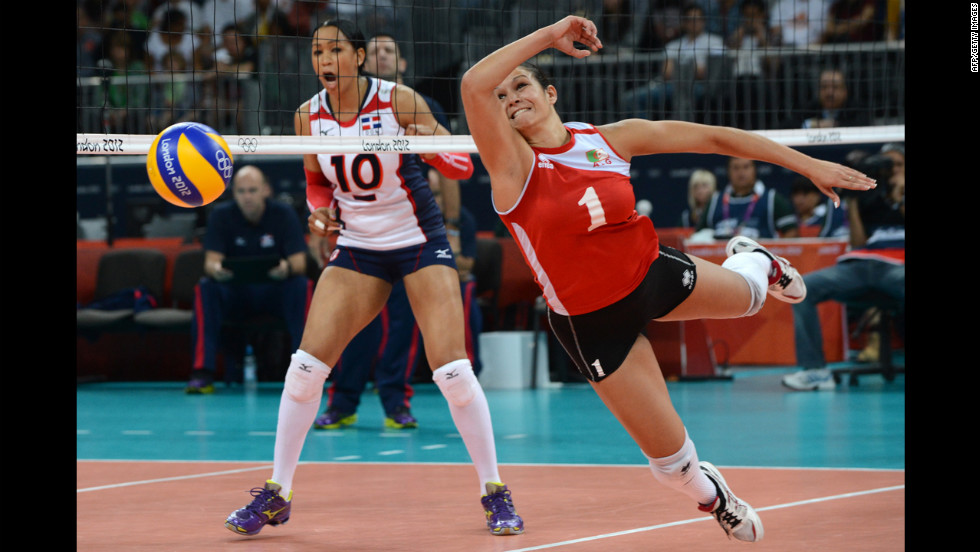 Algeria&#39;s Sehryne Hennaoui, right, dives for a shot during the women&#39;s preliminary pool volleyball match against the Dominican Republic.