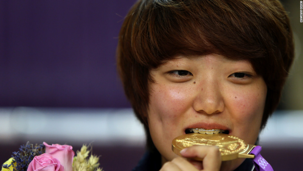 South Korea&#39;s Kim Jang-mi bites her gold medal on the podium after victory in the women&#39;s 25-meter pistol final.