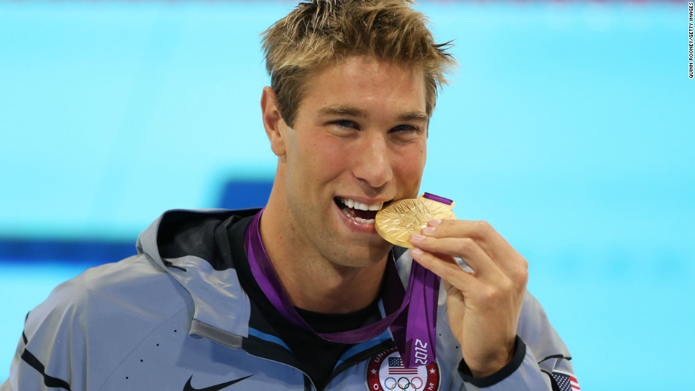 Matt Grevers of the U.S. celebrates with his gold medal during the medal ceremony for the men&#39;s 100-meter backstroke.
