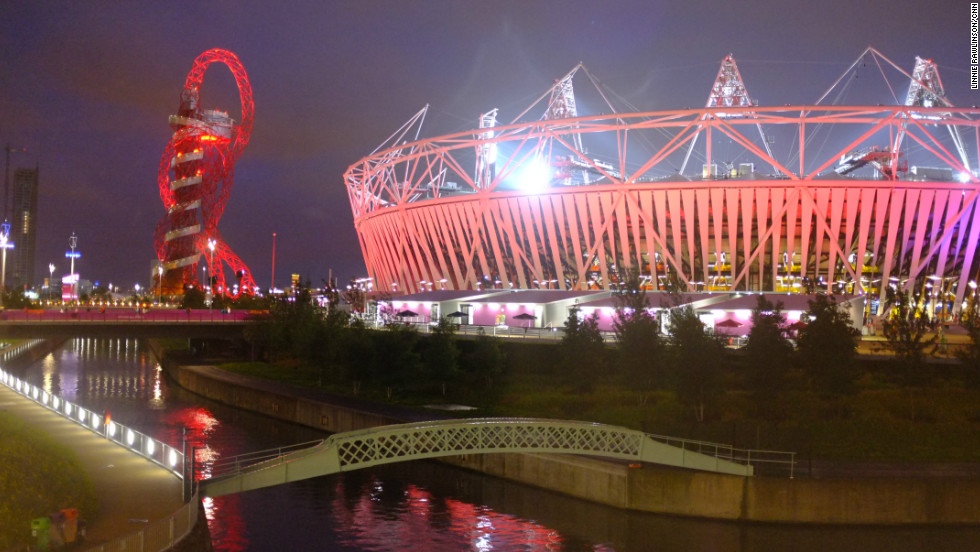 The stadium and the Orbit stood out against the cloudy East London sky and reflected in the River Lea, which flows through the park. The stadium was hosting athletics that night. 