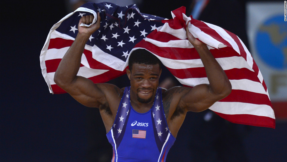 U.S. wrestler Jordan Ernest Burroughs celebrates with the national flag after defeating Iran&#39;s Sadegh Saeed Goudarzi in the men&#39;s freestyle gold medal match.