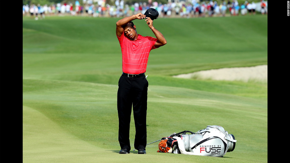 Woods, who finished the third round with a 74, wipes his brow between holes.