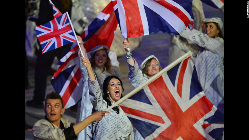 Artists wave Union Jack flags as they perform during the closing ceremony.