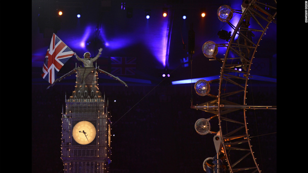 An actor waves a Union Jack from atop a mockup of the Big Ben tower.