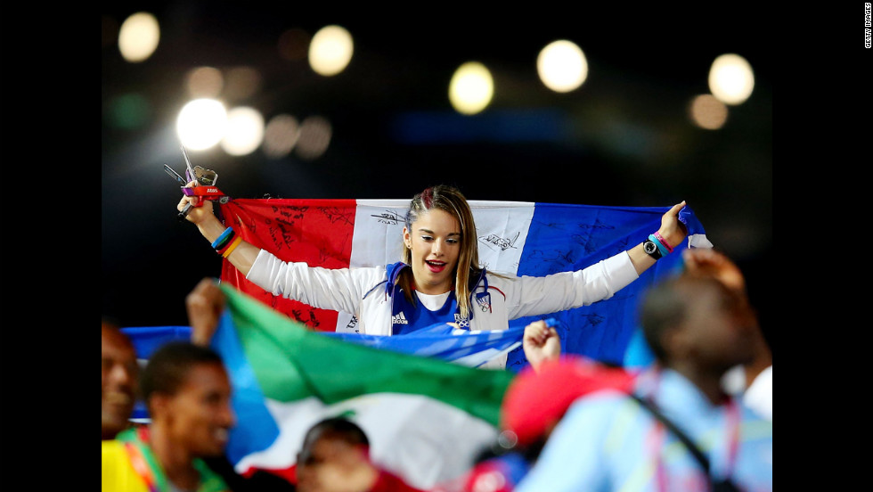 A  French athlete carries her nation&#39;s flag as the French team parades through the stadium.