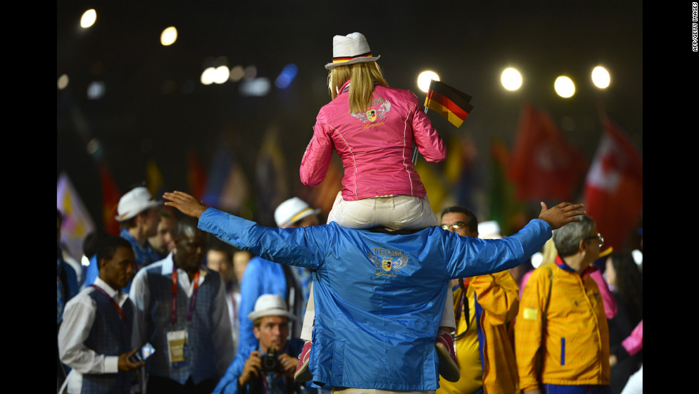 A female athlete from Germany rides on the shoulders of a male teammate during the closing ceremony.