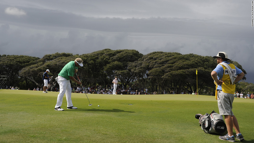 Carl Pettersson of Sweden tries a putt from the edge of the green as storm clouds move in.