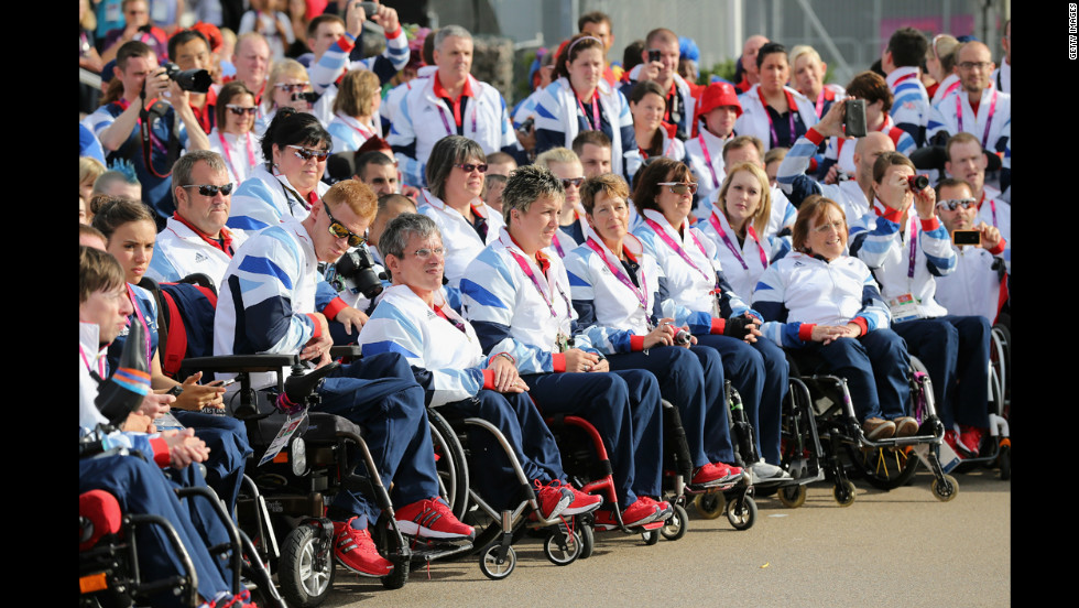 Members of Team GB Paralympic look on as they are welcomed by dancers during a ceremony at the Paralympic Village.