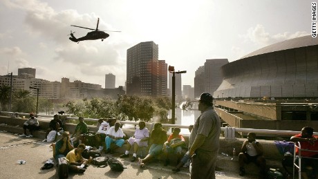 NEW ORLEANS - AUGUST 31: People seek high ground on the I 90 Freeway as a helicopter prepares to land at the Supedome August 31, 2005 in New Orleans, Louisiana. Devastation is widespread throughout the city with water approximately 12 feet high in some areas. Hundreds are feared dead and thousands were left homeless in Louisiana, Mississippi, Alabama and Florida by the storm.  (Photo by Mark Wilson/Getty Images)