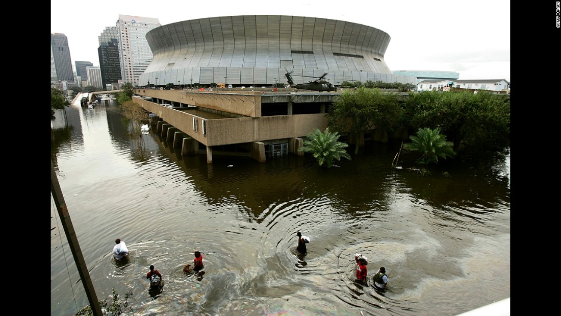 People wade through high water in front of the Superdome in New Orleans on August 30, 2005.