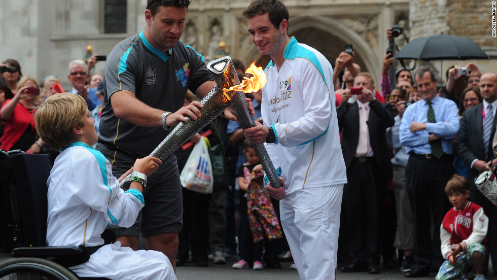 Torchbearers exchange the Paralympic flame outside Westminster Abbey in London on Wednesday, August 29.