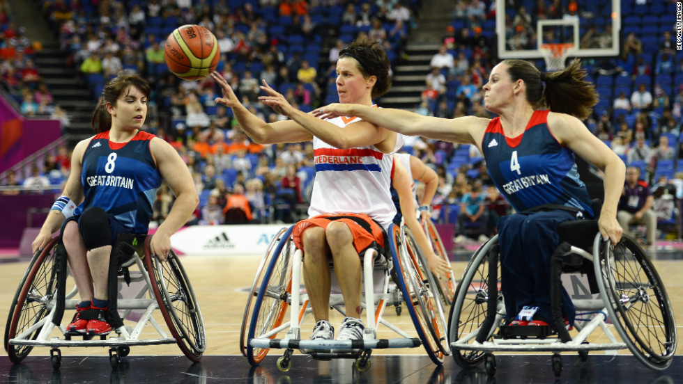 The Netherlands&#39; Inge Huitzing passes the ball as Britain&#39;s Laurie Williams, left, and Caroline Maclean defend during the preliminary women&#39;s group A wheelchair basketball match.