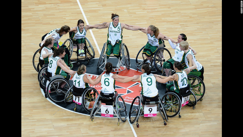 The Australian women&#39;s wheelchair basketball team huddles and celebrates their victory during their preliminary basketball game against Brazil.